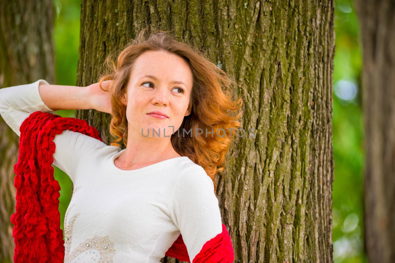 portrait of a girl on a background of a tree looking to the side