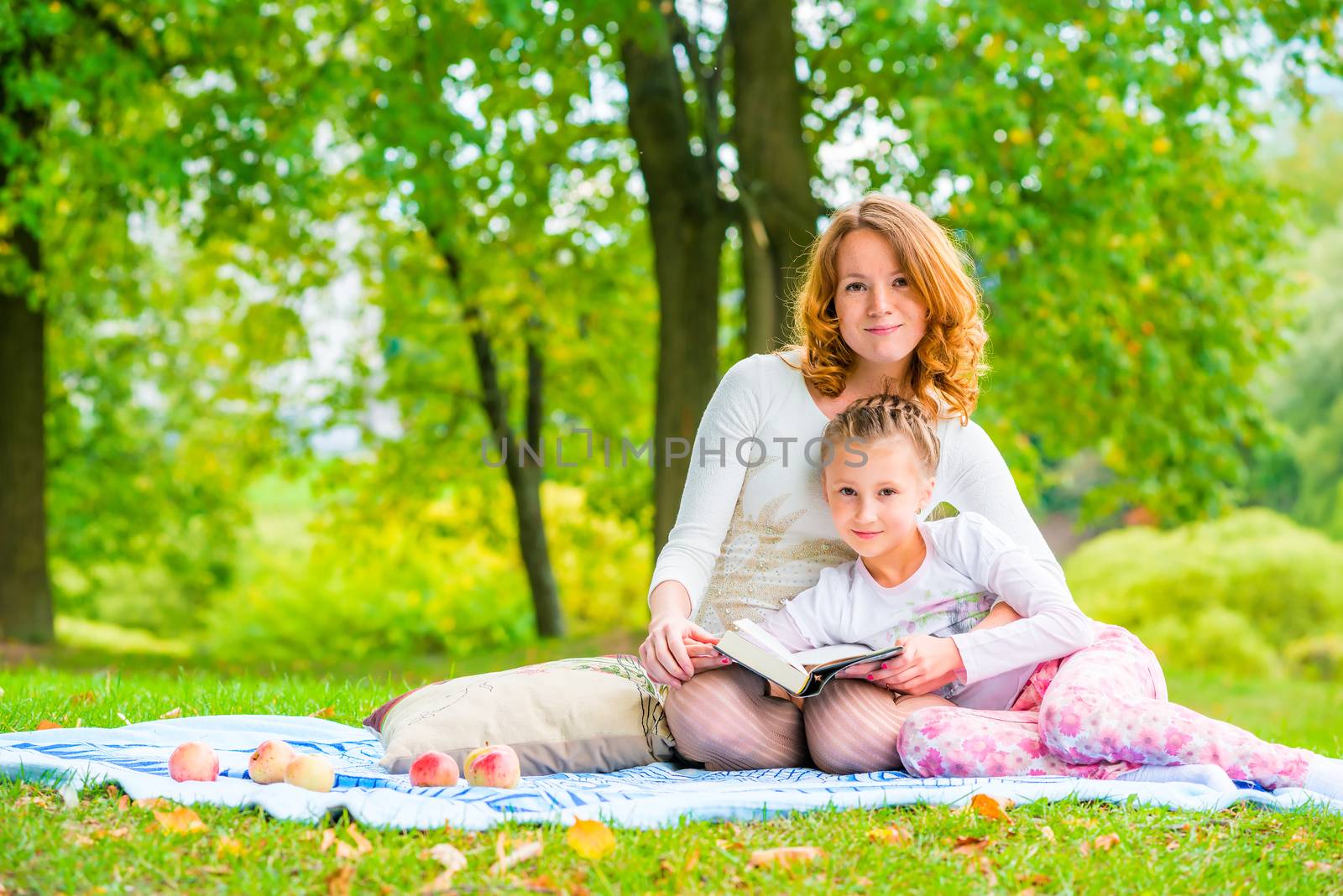 Beautiful mother and daughter spend a weekend at a picnic in the park