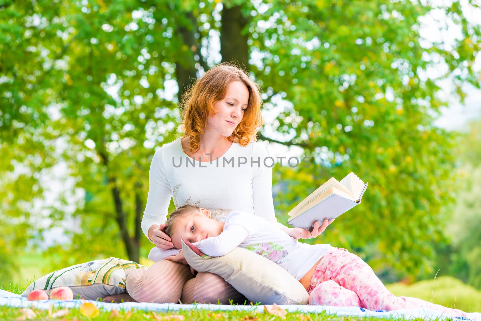 mother reads her daughter's interesting book on the nature