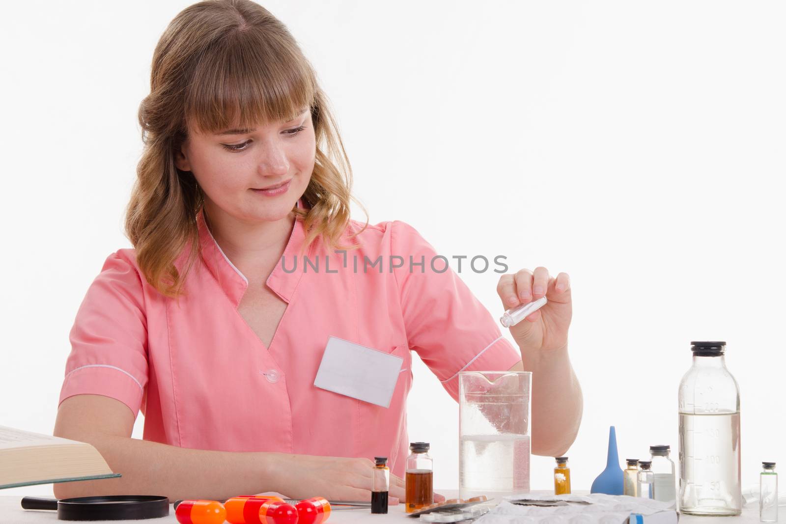 Pharmacist sitting at the table reading a thick handbook of medicines