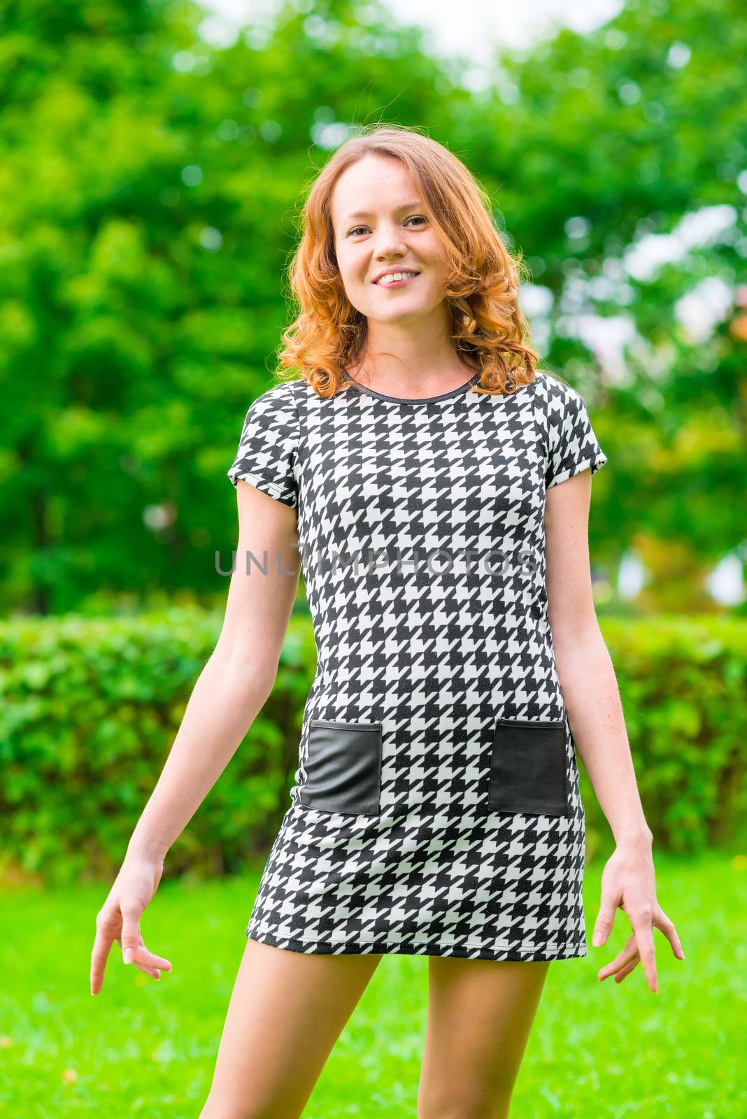 cute girl in a checkered dress in summer park