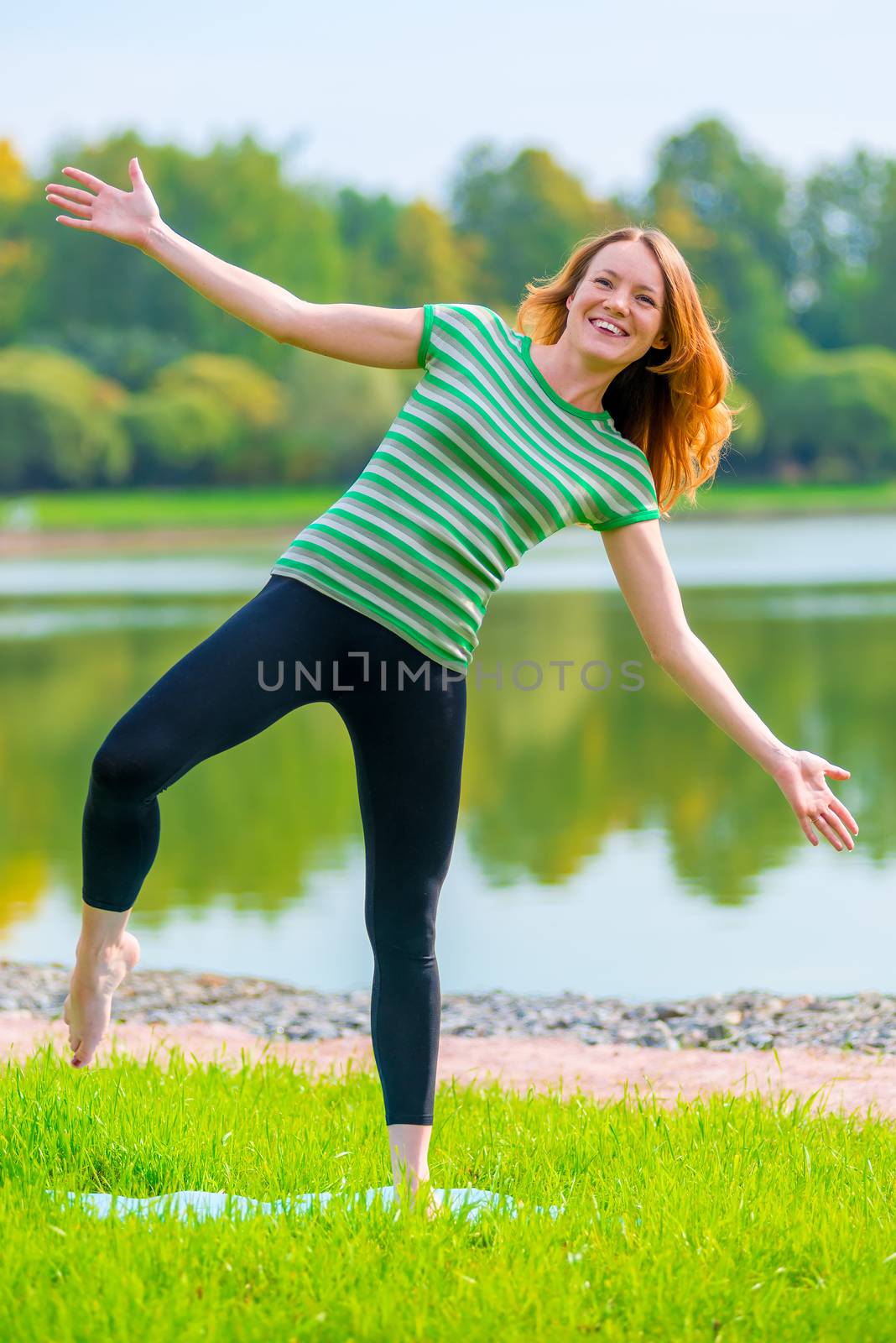 cheerful girl is trying to keep his balance on one leg