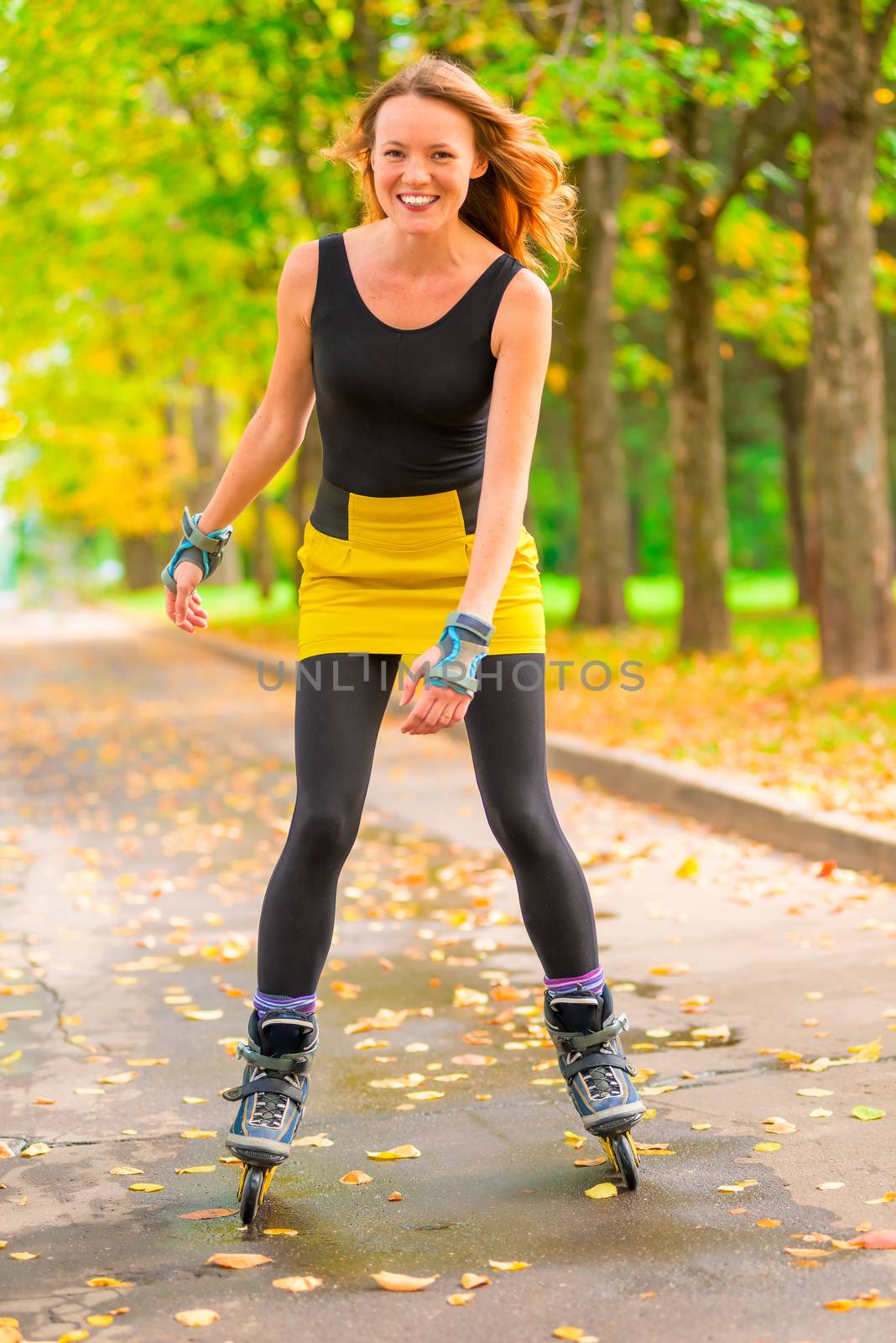 portrait of laughing slim girl on roller skates