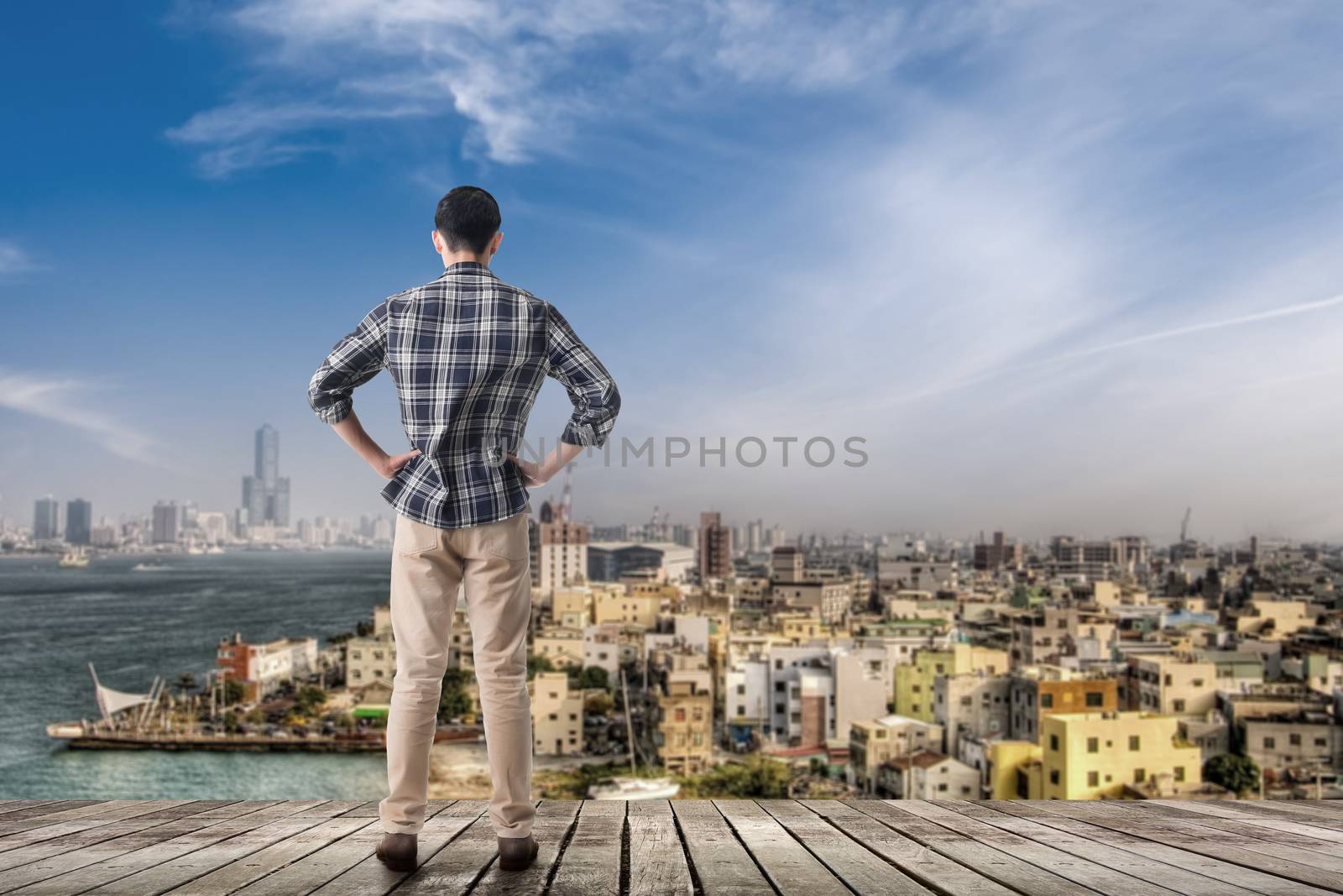 Asian man standing and looking the skyline of the city, Kaohsiung, Taiwan, Asia.