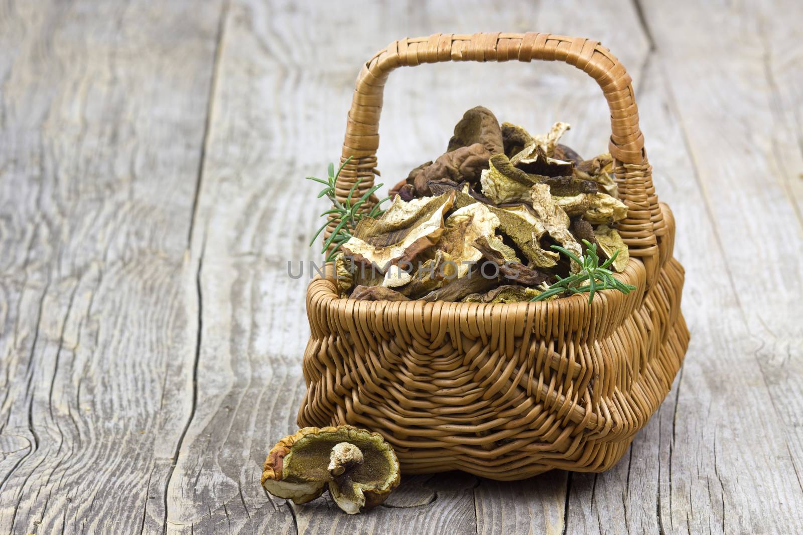 dried mushrooms in a basket on wooden background