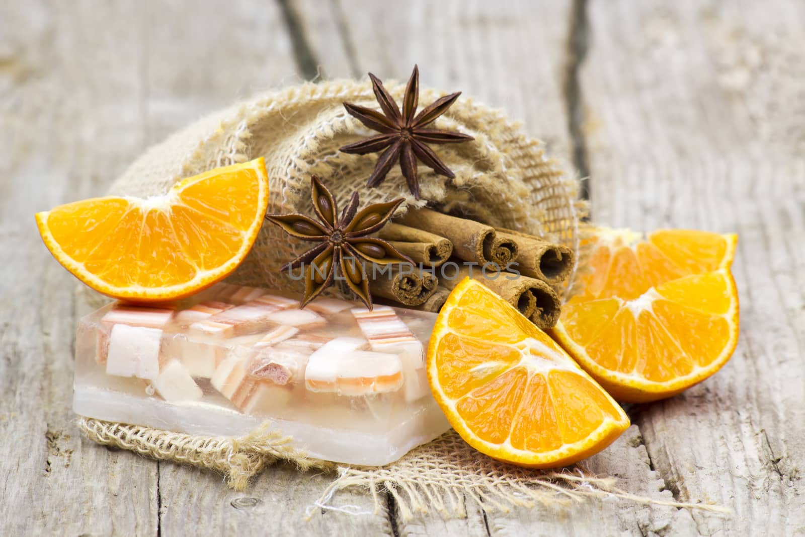 aromatic glycerin soap, orange and spices on wooden background by miradrozdowski