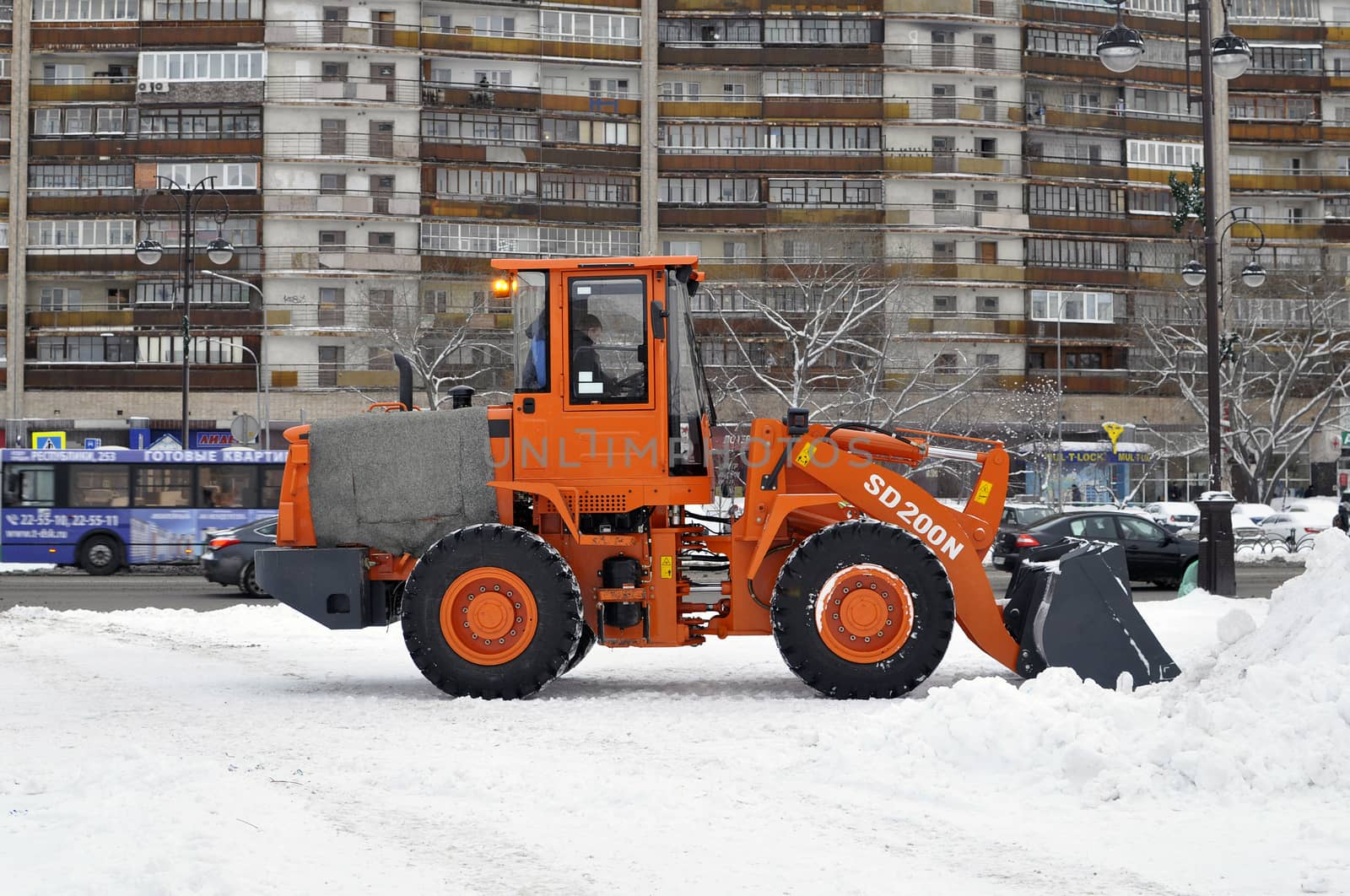 The bulldozer occupied with snow cleaning costs on the street in the city of Tyumen
