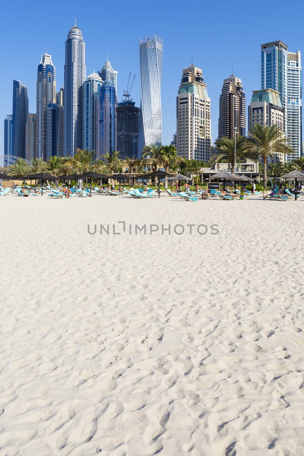 DUBAI, UAE - November 28: Tourists on city beach, November 28, 2014 in Dubai. More than 10 million people visit the city every year. 