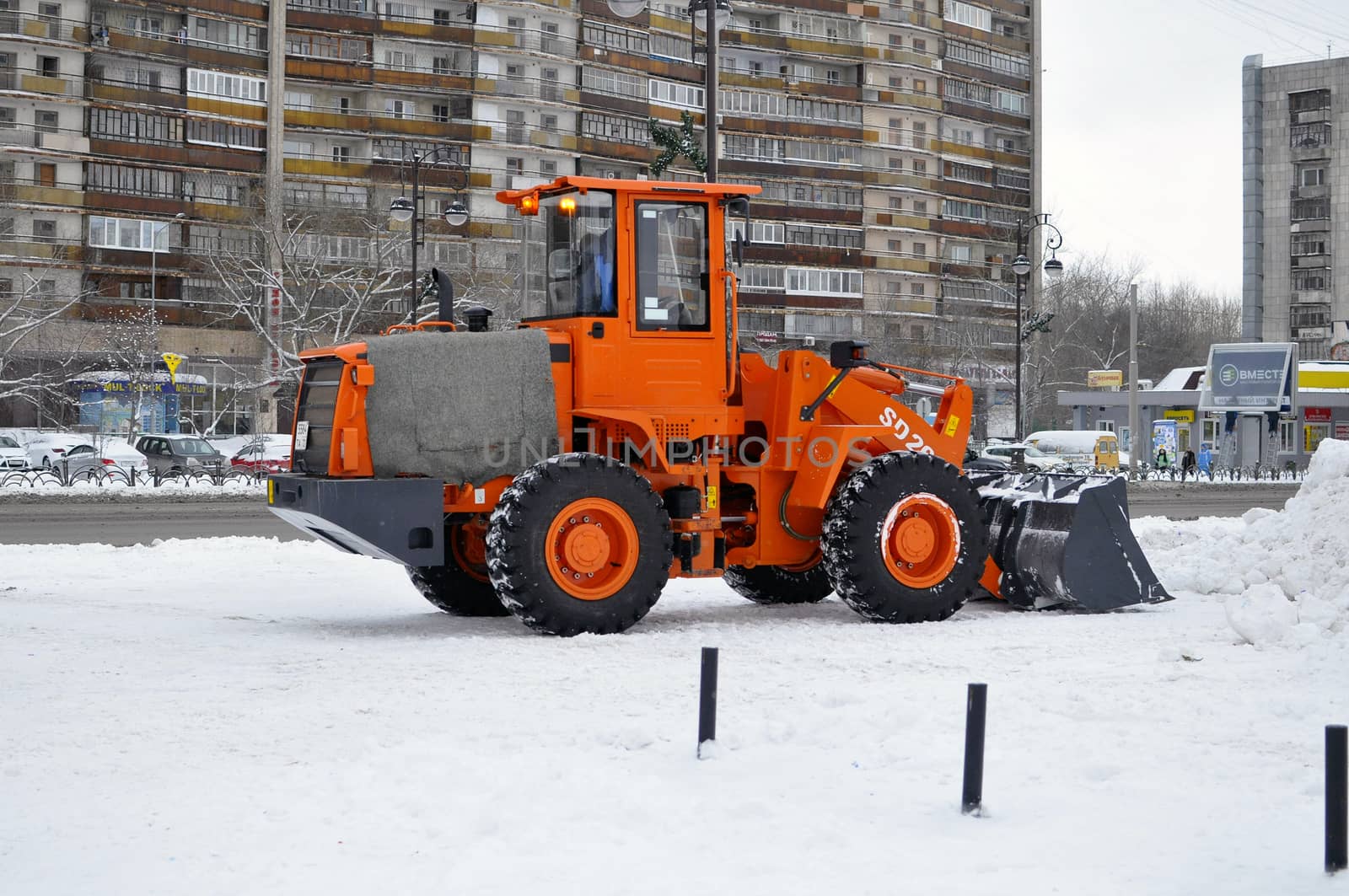 The bulldozer occupied with snow cleaning costs on the street in the city of Tyumen