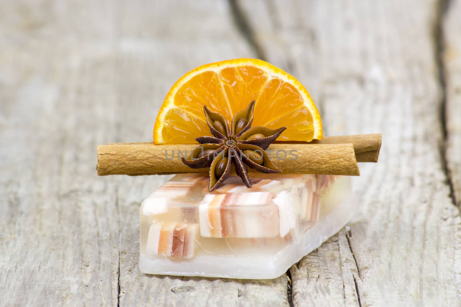 aromatic glycerin soap, orange and spices on wooden background