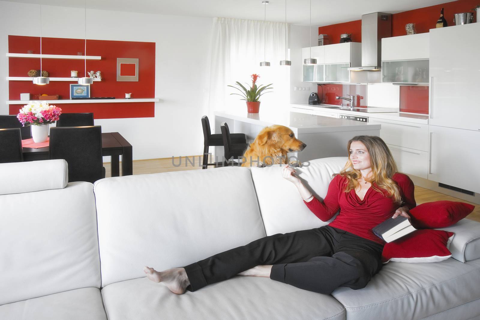 young beautiful woman sitting on soffa in modern kitchen interior