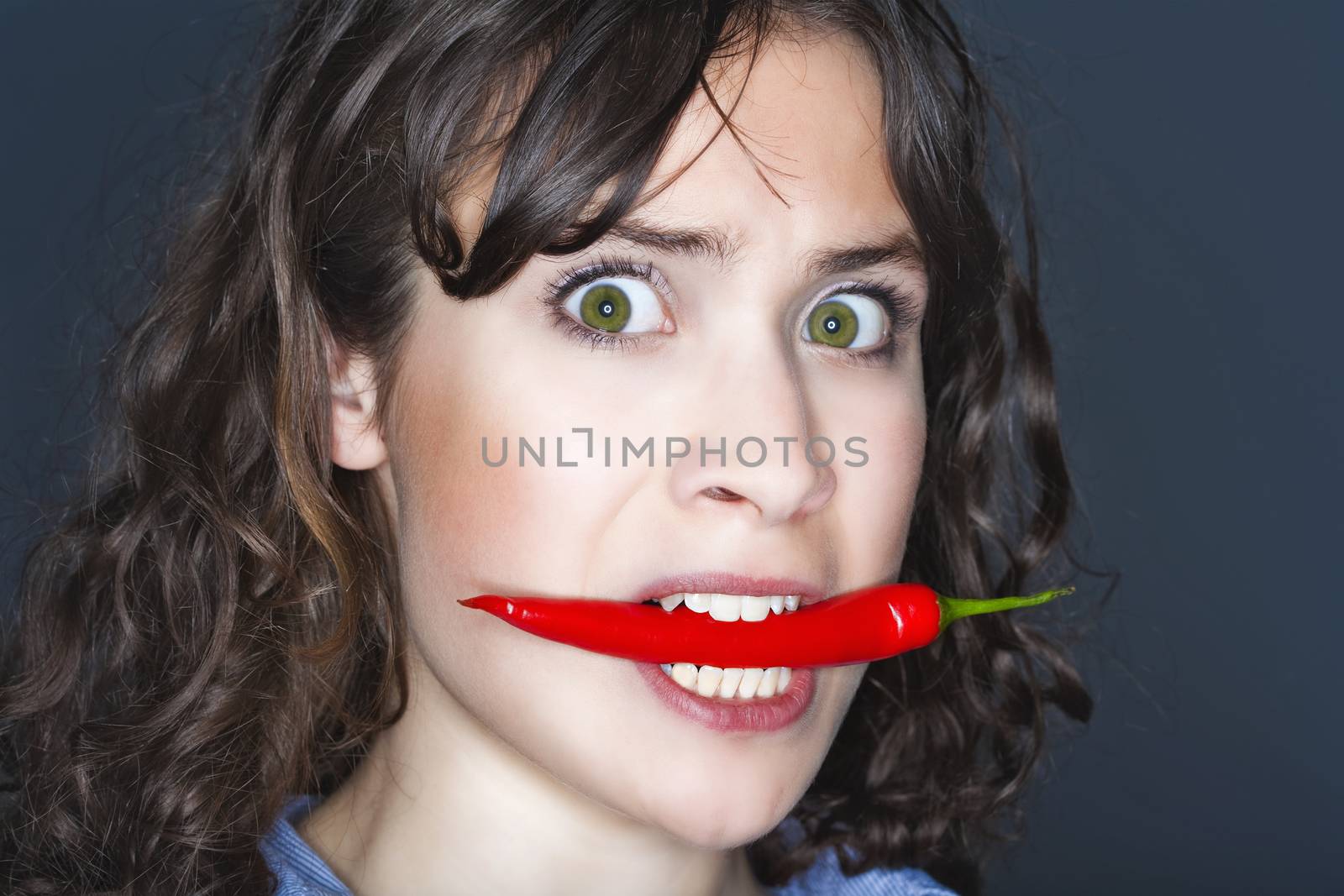 woman holding chili in her mouth by courtyardpix