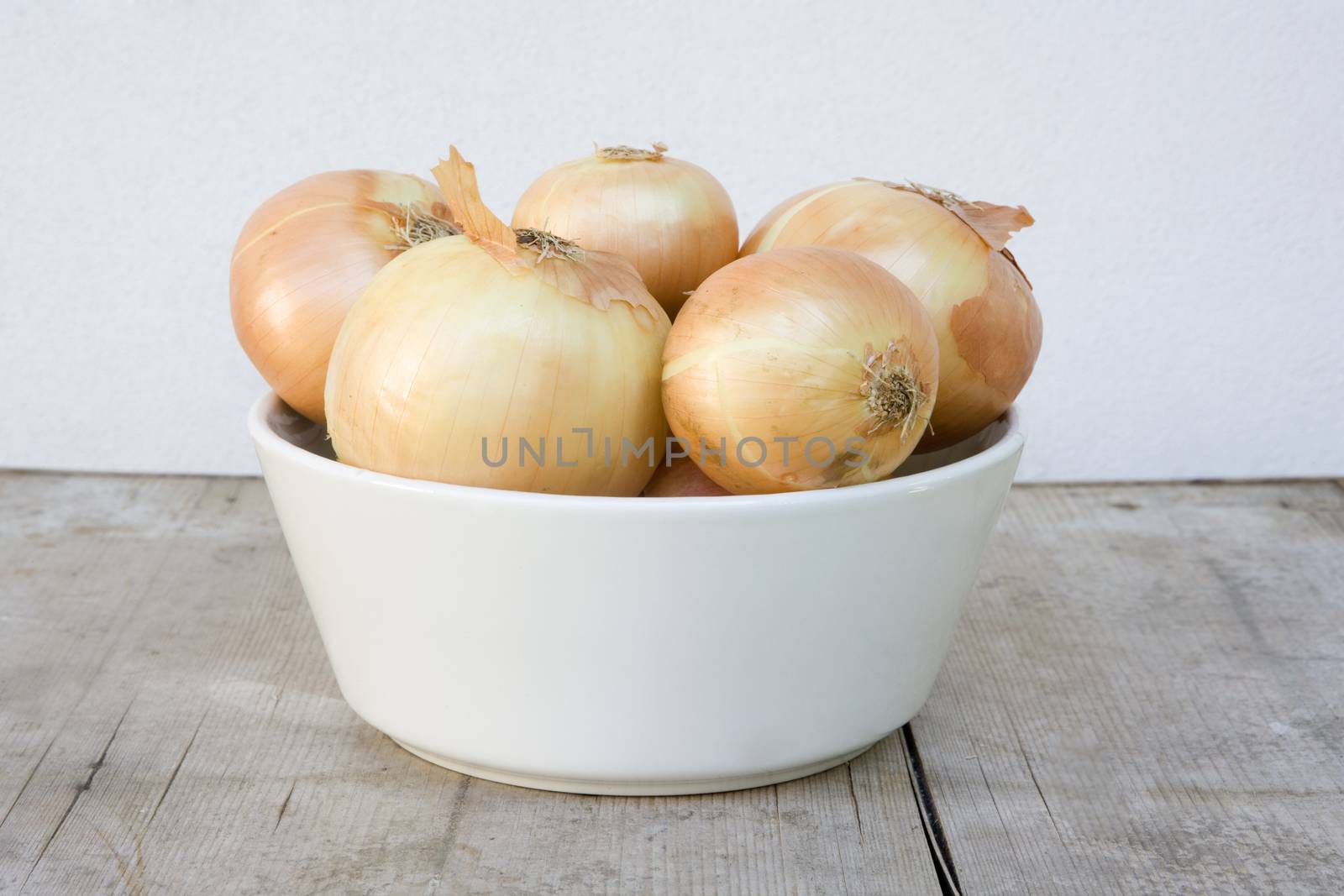 white bowl with brown onions on wooden board