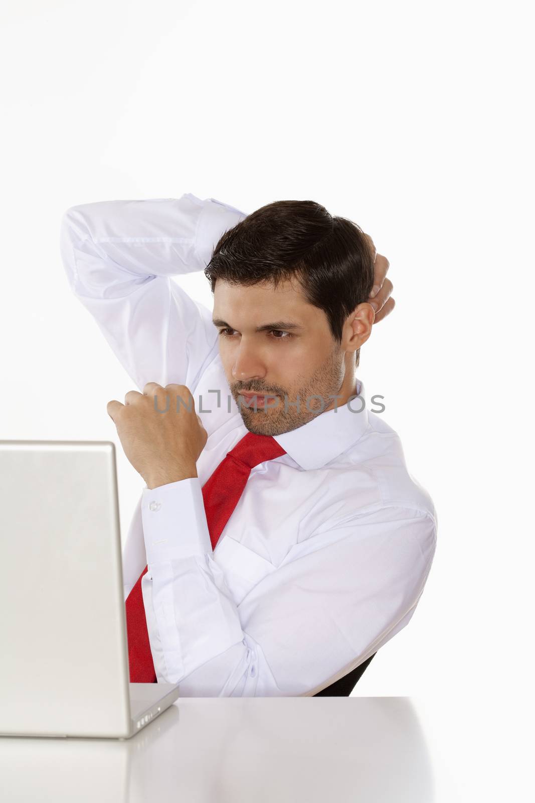 young business executive in white shirt behind desk with laptop
