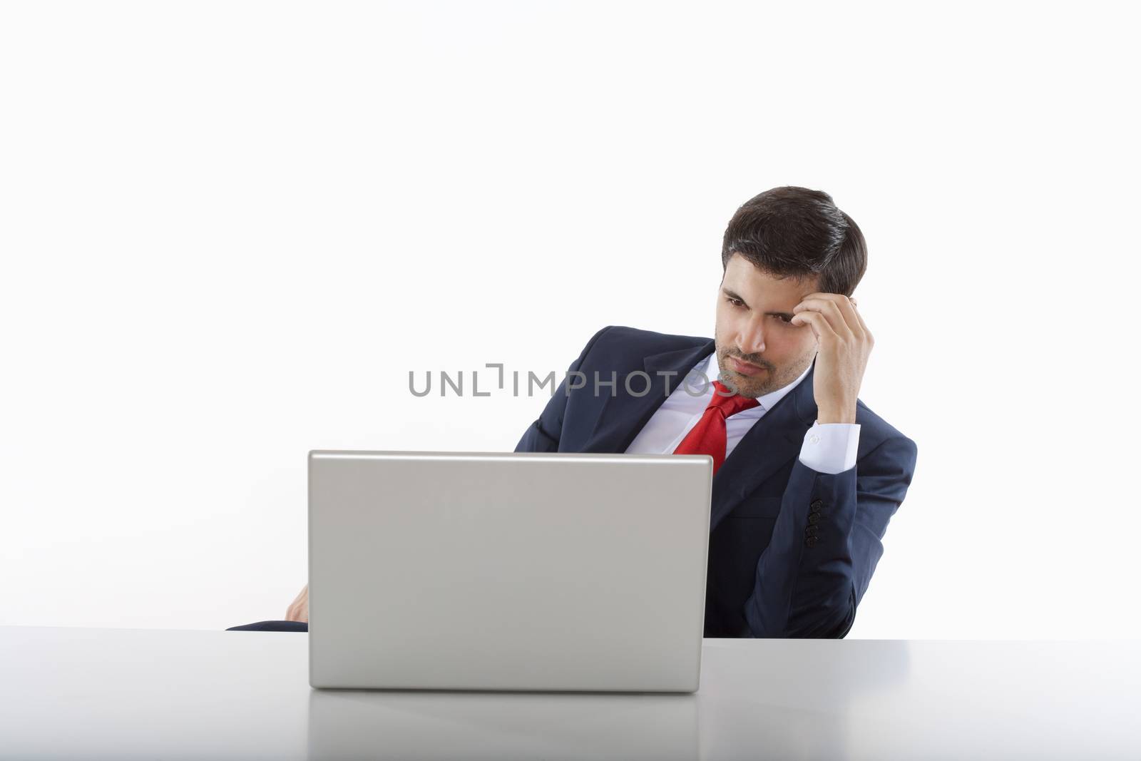 young business executive in suit behind desk with laptop