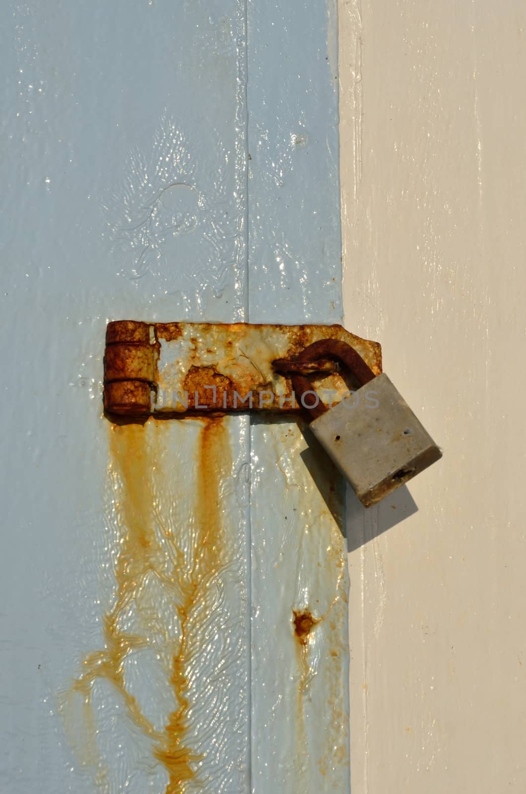 Old padlock on blue wooden background