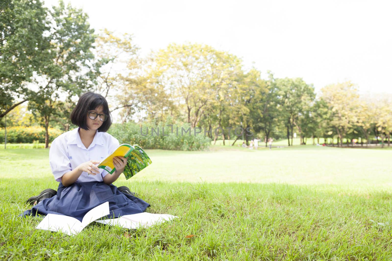 Schoolgirl was reading on the lawn. Enjoy and happy in the garden.