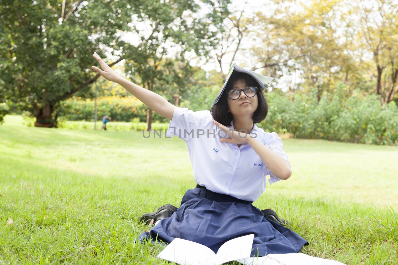 Girl is happy and relaxed. Sitting on the grass in the garden. While being homework