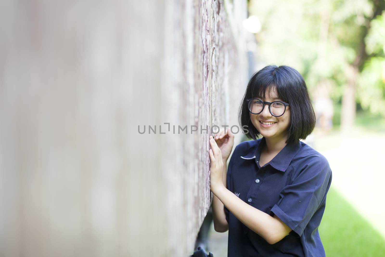 Portrait Girl with short hair and glasses. Smiling a happy holiday in the park.
