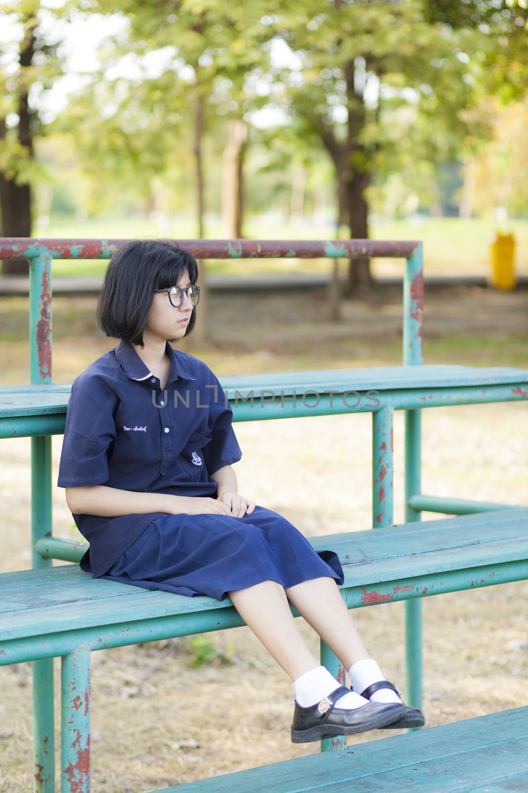 Girl wearing glasses sitting on the bench. by a454