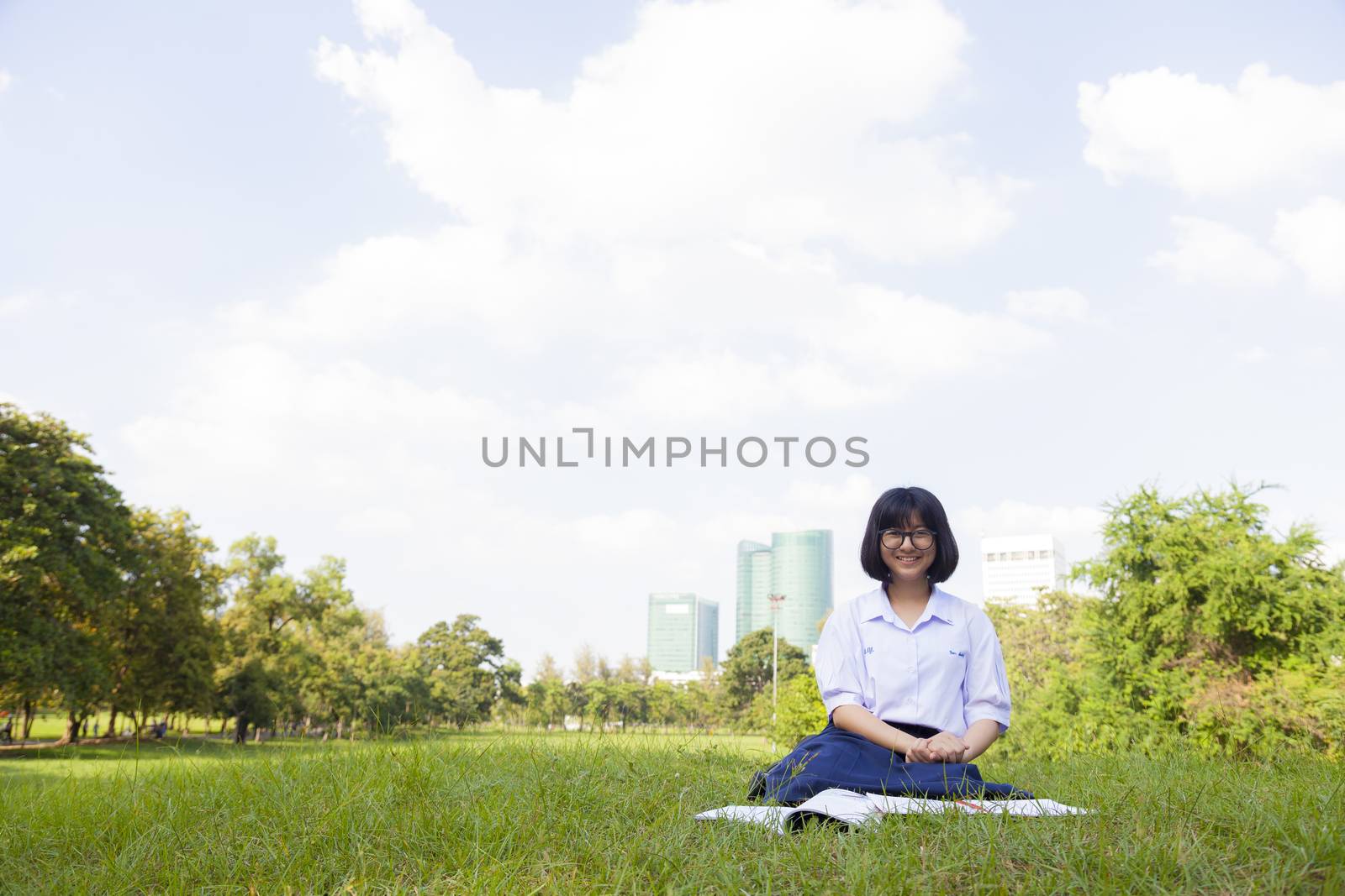 Girl sitting and smiling. On the lawn a happy and relaxation. On a clear sunny sky.