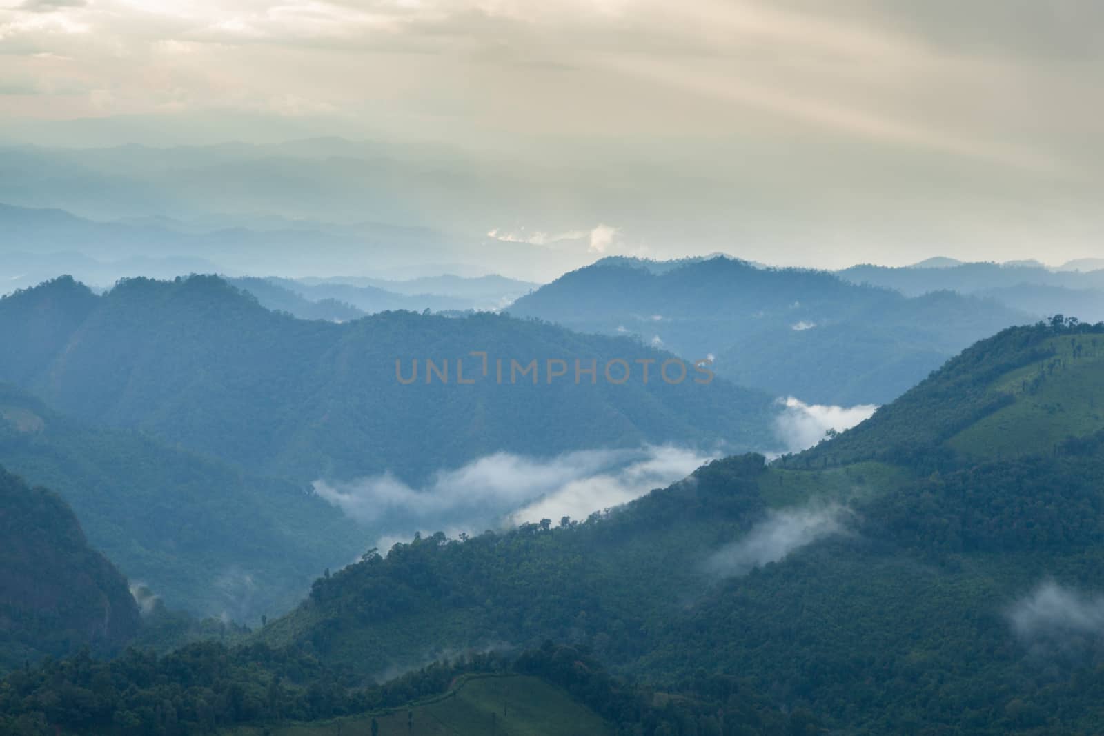 mist-shrouded mountains. High mountain complex. Fog in the morning and evening.