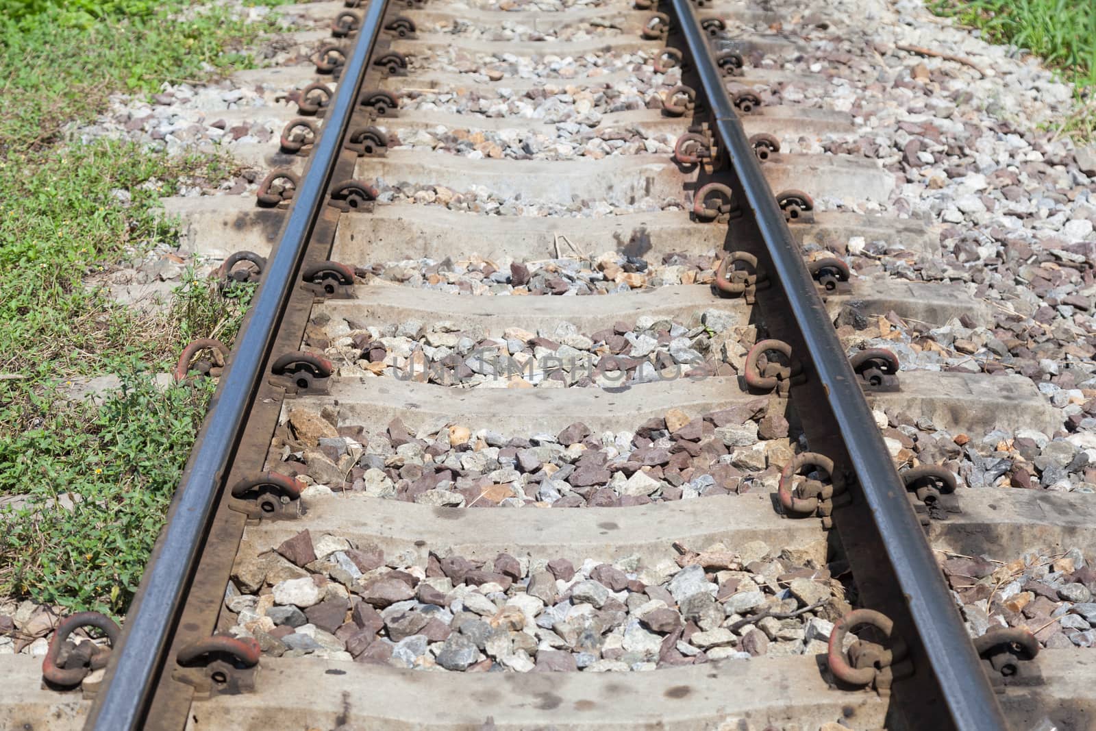 Railroad tracks. With iron bars and cement. A rock base of the tracks.