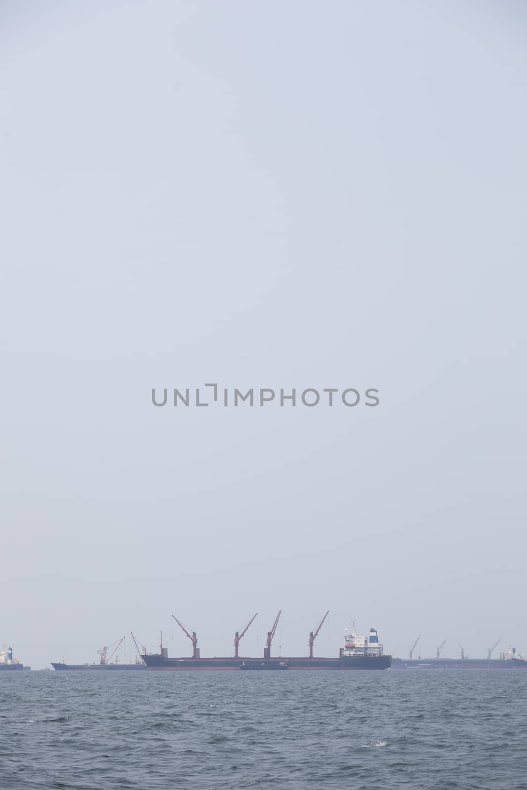 Large cargo ship Boats moored in the sea to make sense compared to the coast.