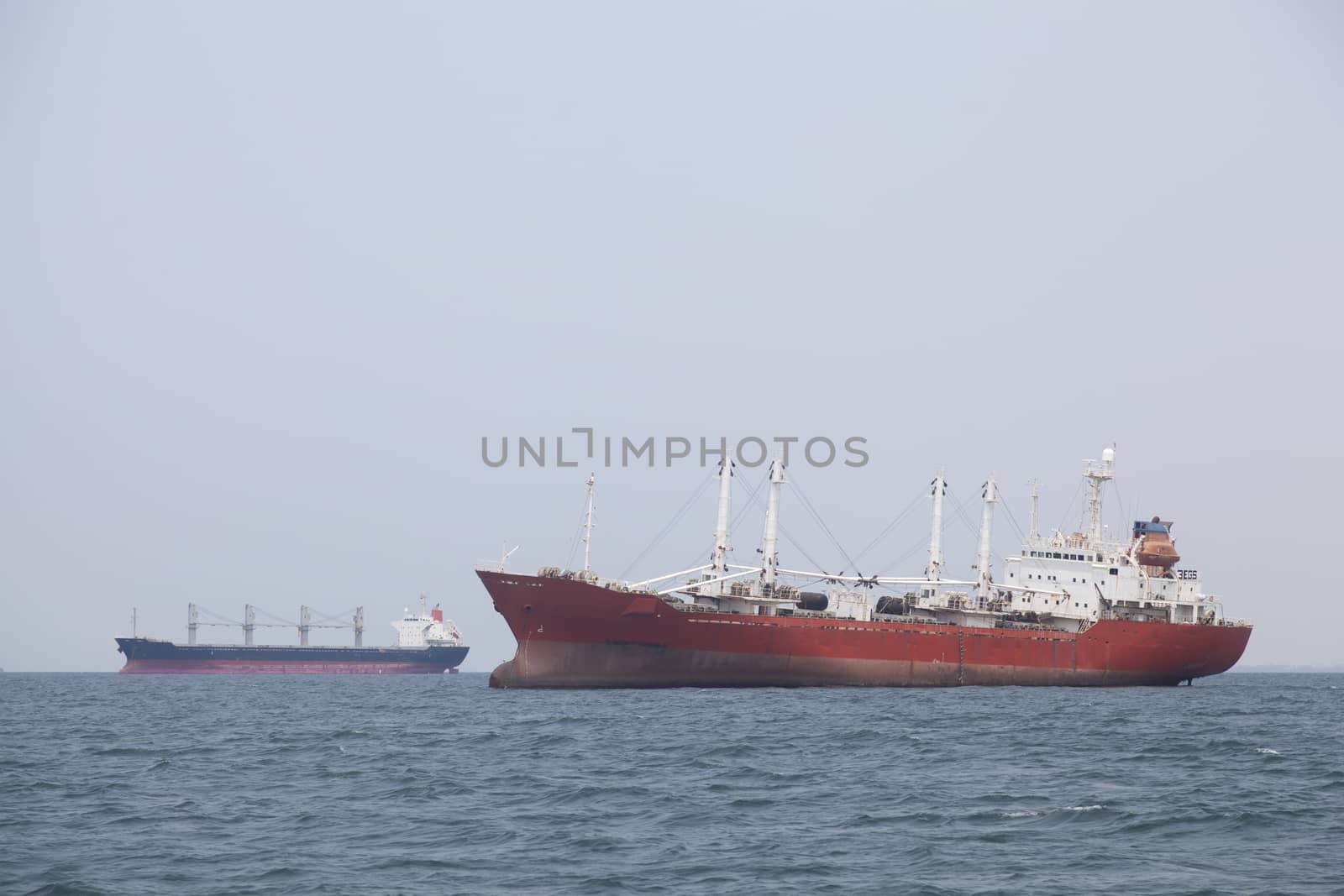 Large cargo ship Boats moored in the sea to make sense compared to the coast.