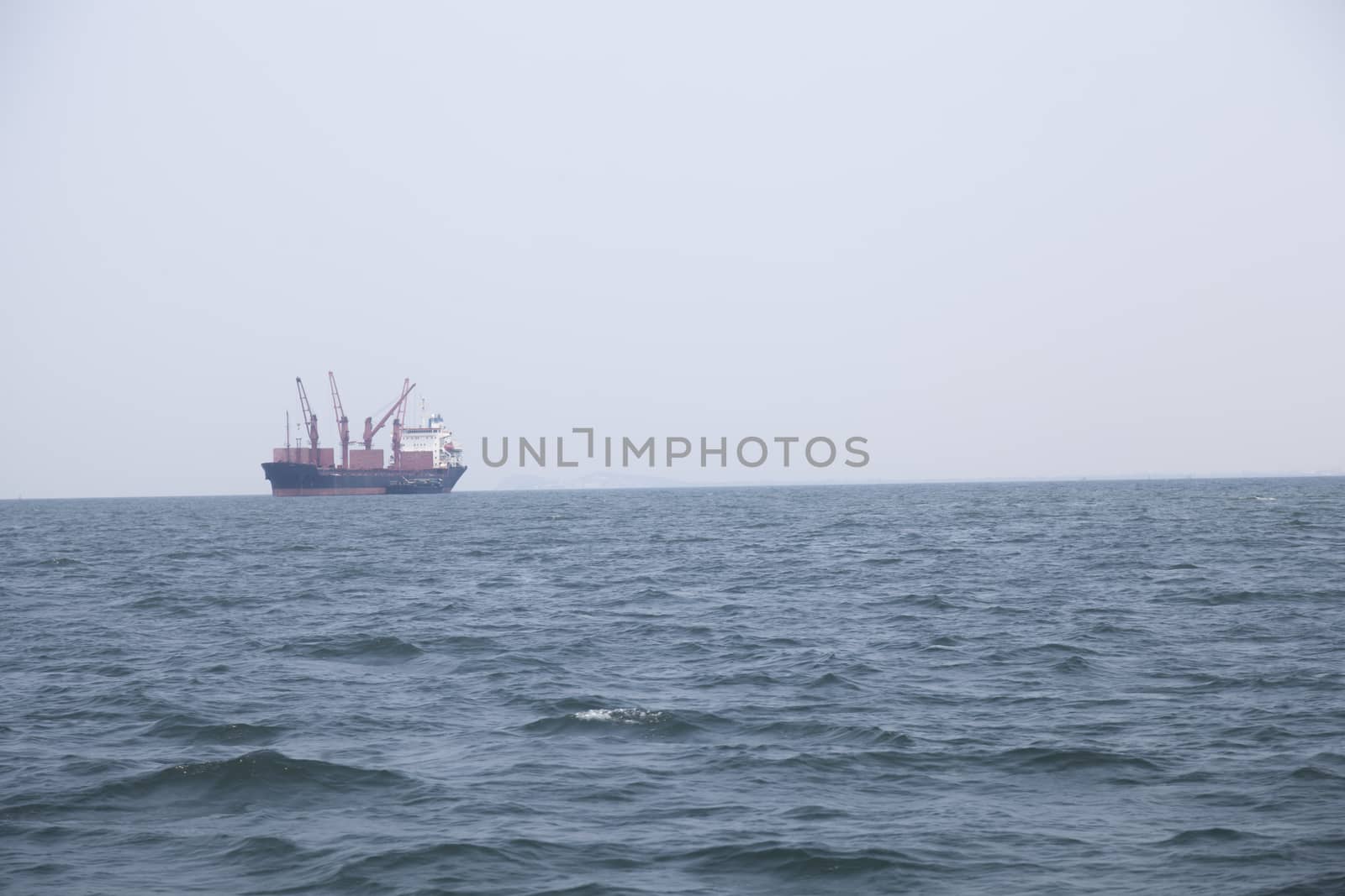 Large cargo ship Boats moored in the sea to make sense compared to the coast.