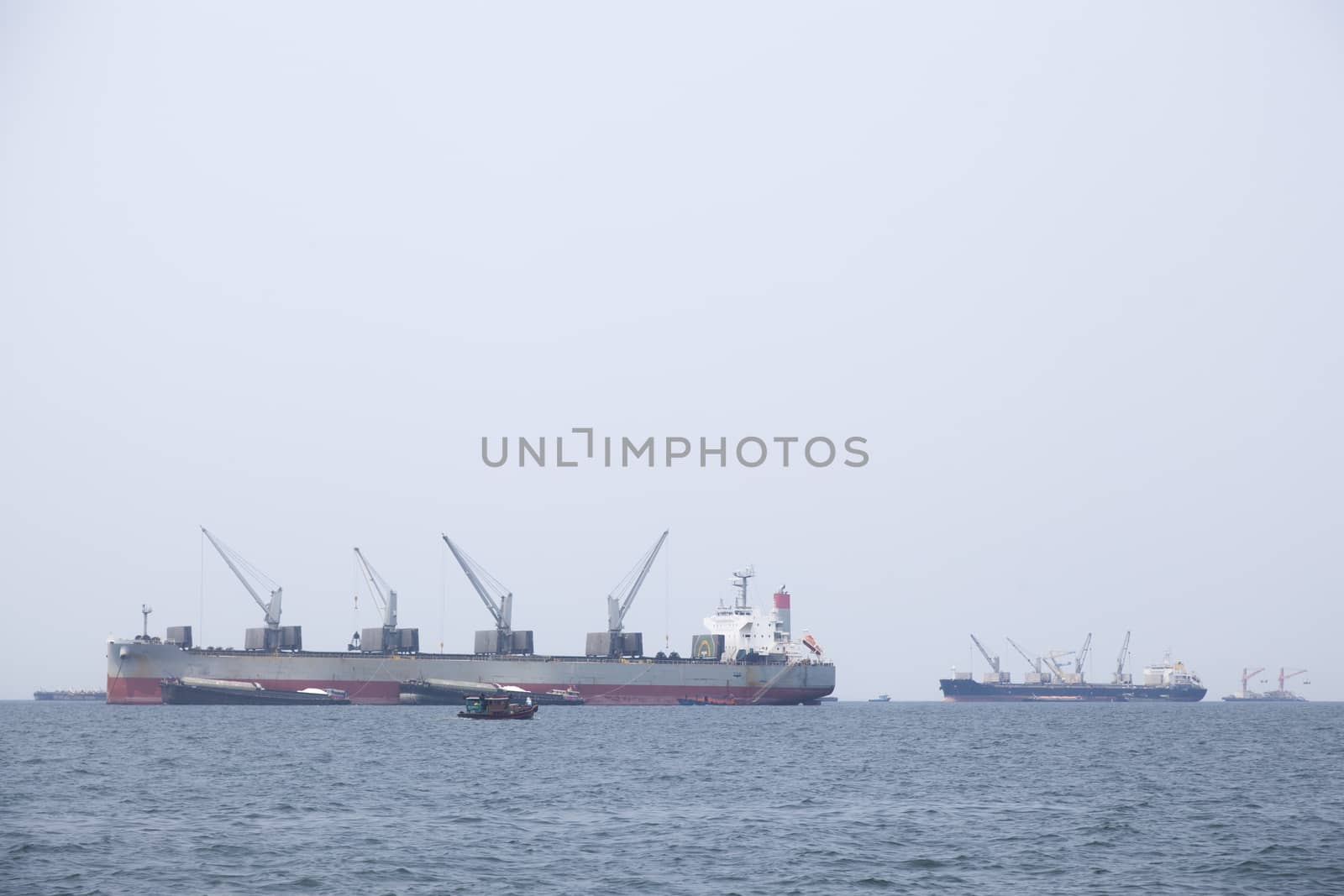 Large cargo ship Boats moored in the sea to make sense compared to the coast.