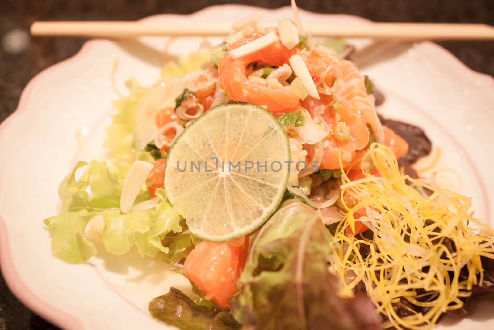 Salmon spicy salad on white plate, stock photo