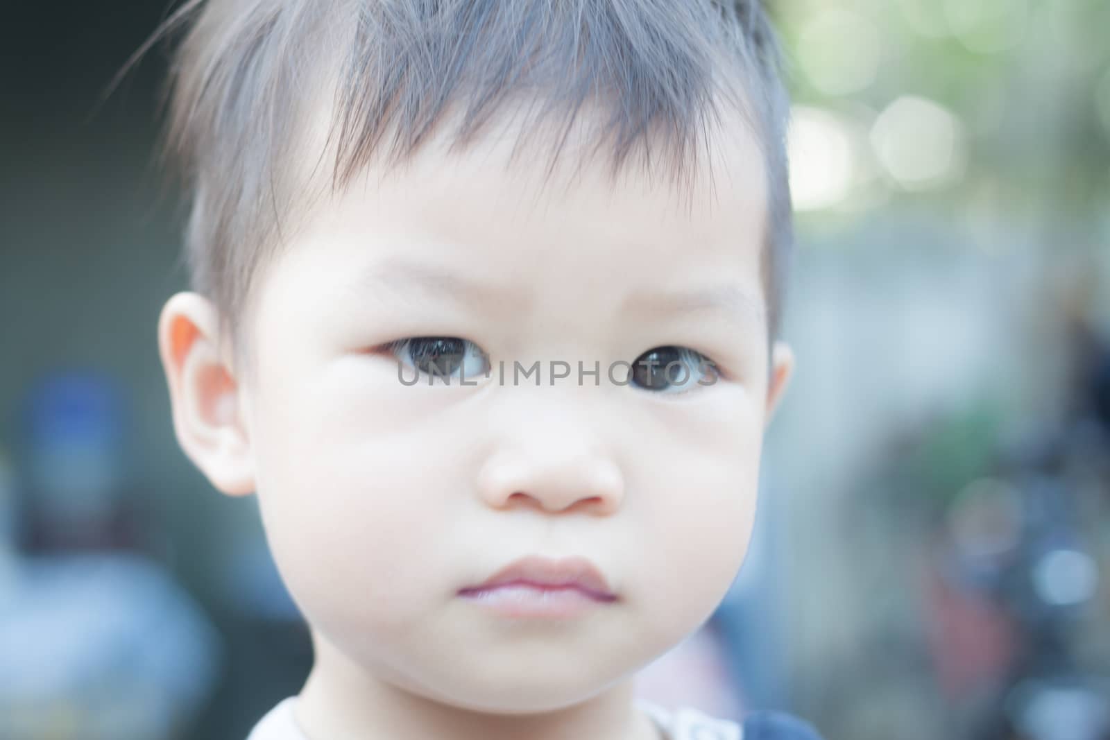 Little asian boy looking at camera  by punsayaporn