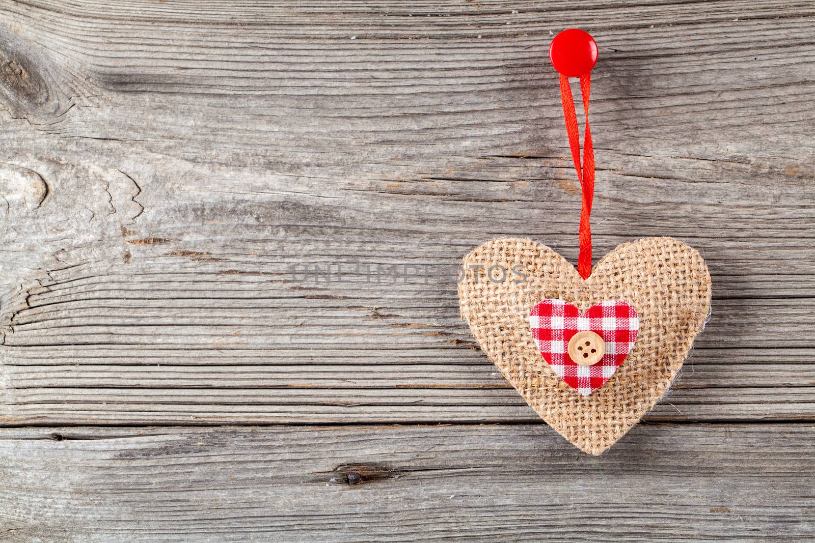 Heart shaped decoration made of wood, over wooden background