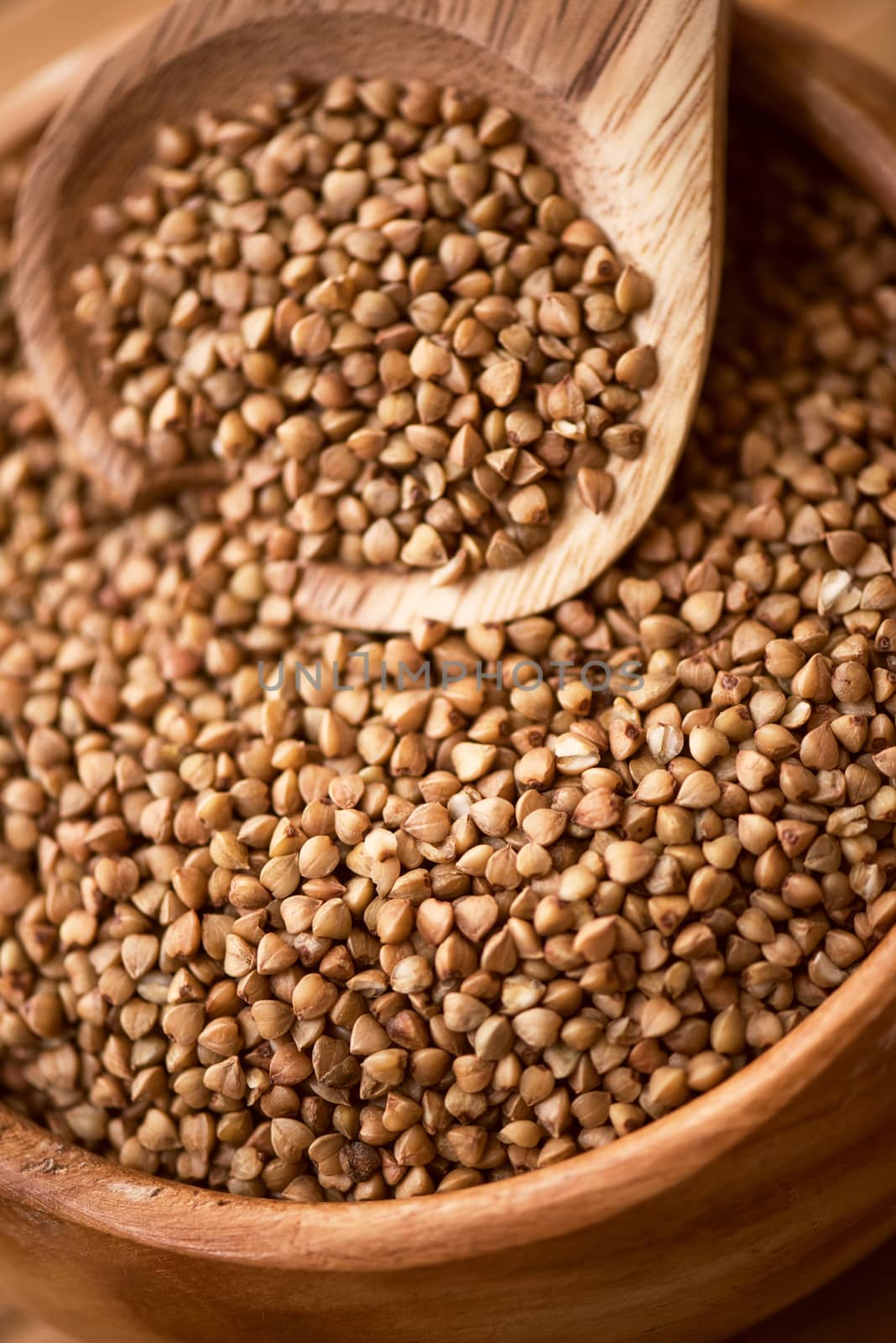 buckwheat at wooden plate on wooden background