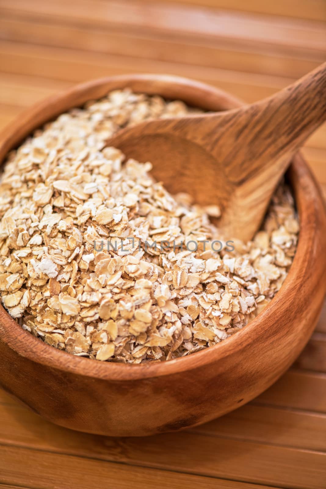 Oat flakes at wooden plate on wooden background