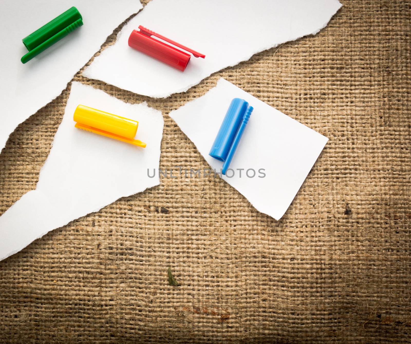 Four white paper pieces decorated with four different colours