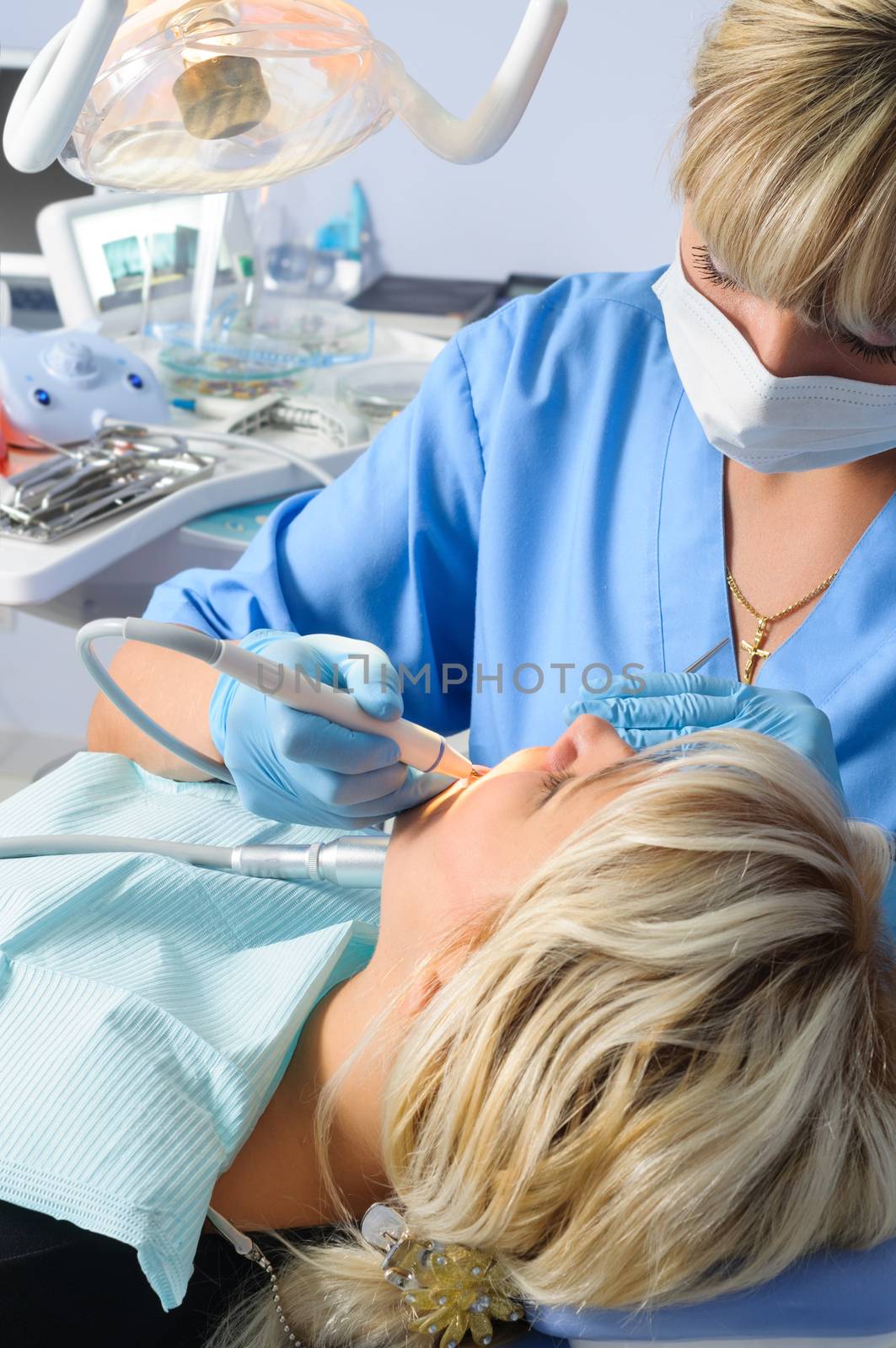 dentist at work with patient, expertise, drilling cleaning and curing, using dental water jet