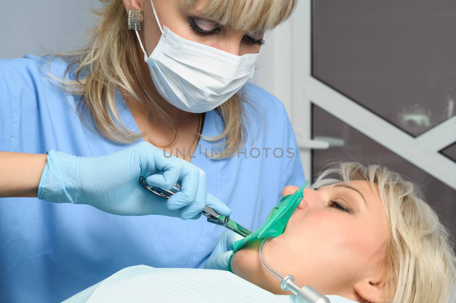 dentist with patient, installation of rubber dam by starush