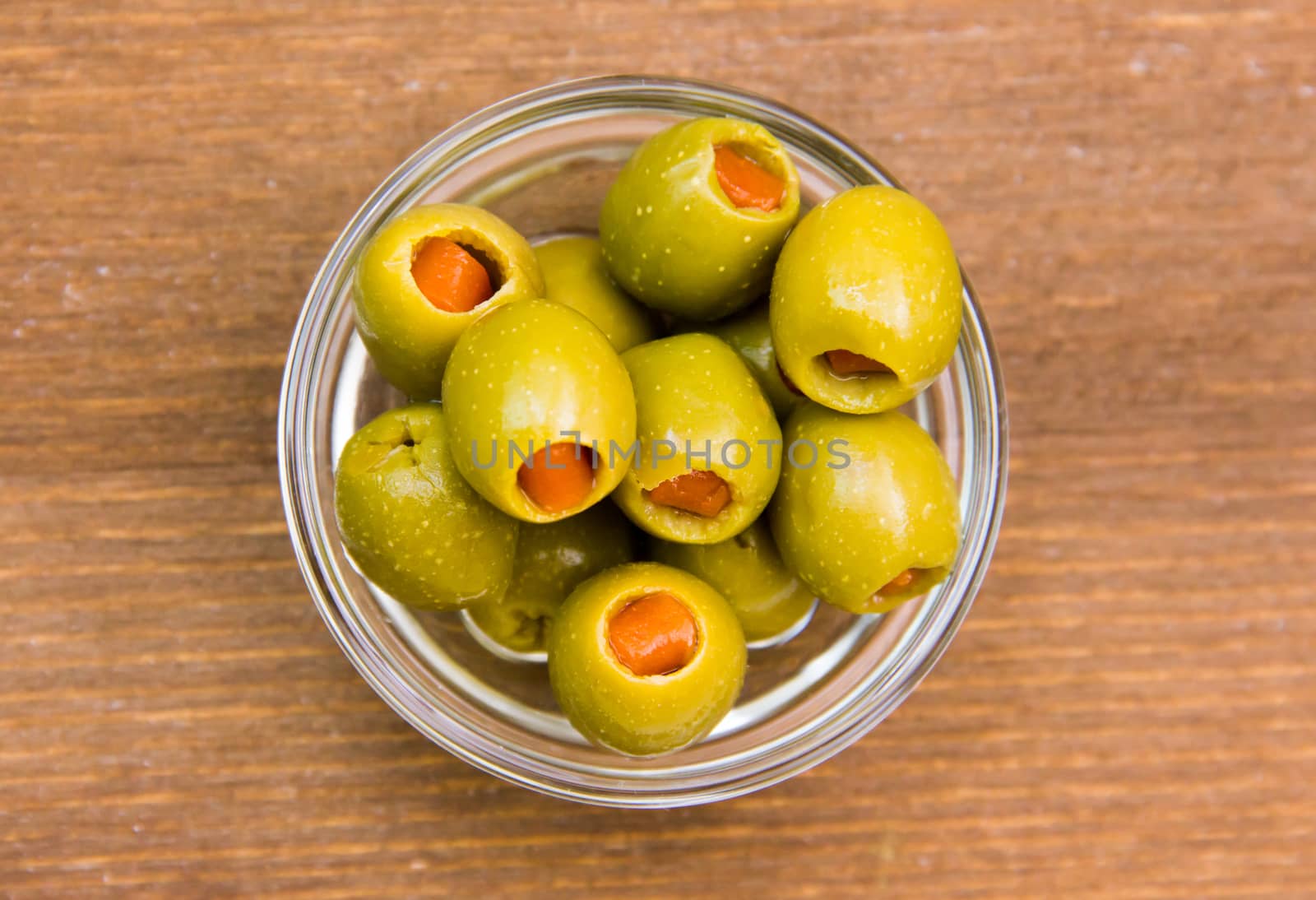 Stuffed olives in bowl on wood from above by spafra