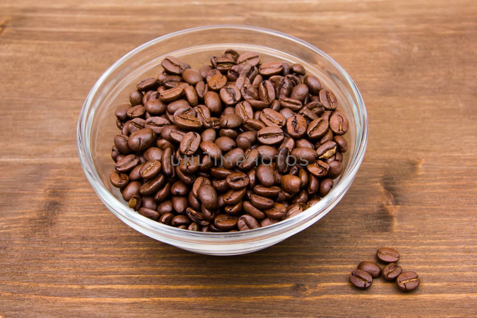 Coffee beans on bowl on wooden table
