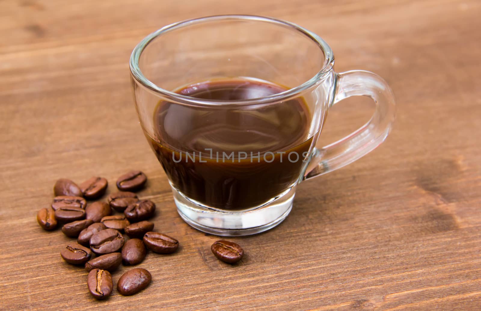 Cup of coffee and coffee beans on wooden closely by spafra