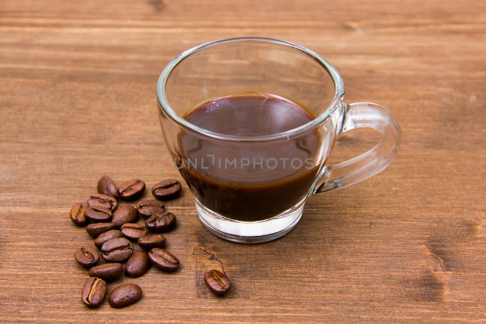 Cup of coffee and coffee beans on wooden table