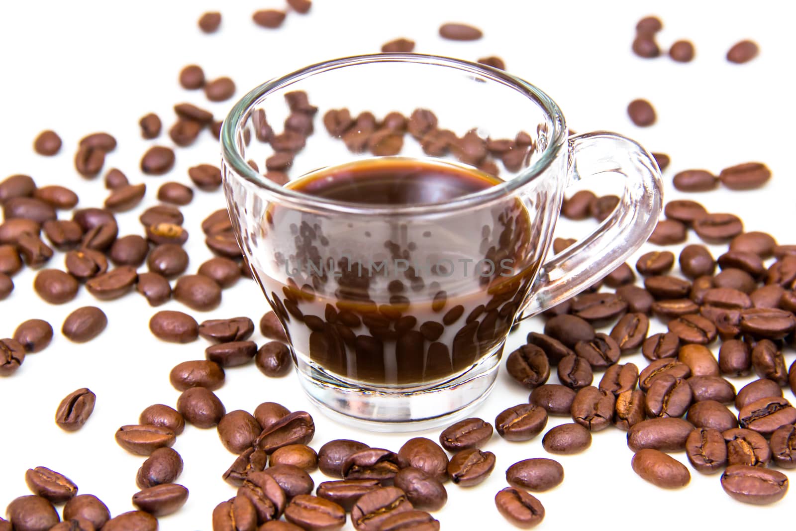 Cup of coffee and coffee beans on white background close up view