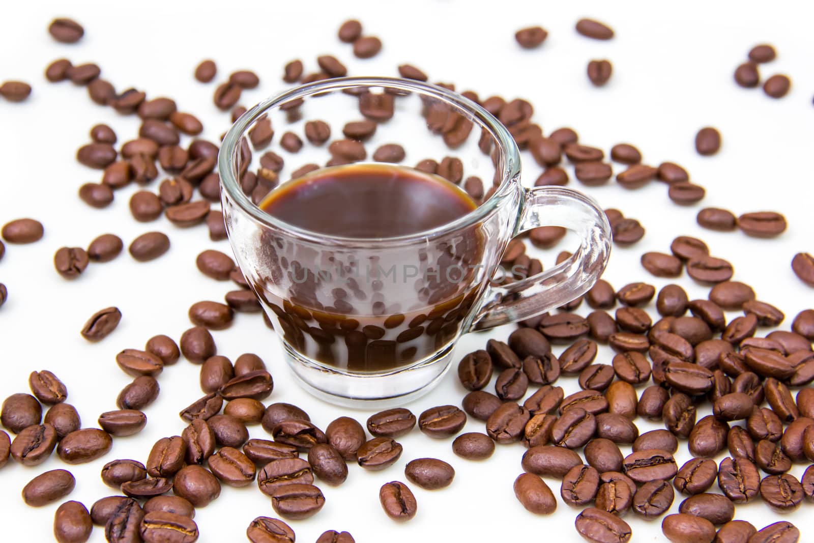 Cup of coffee and coffee beans on white background