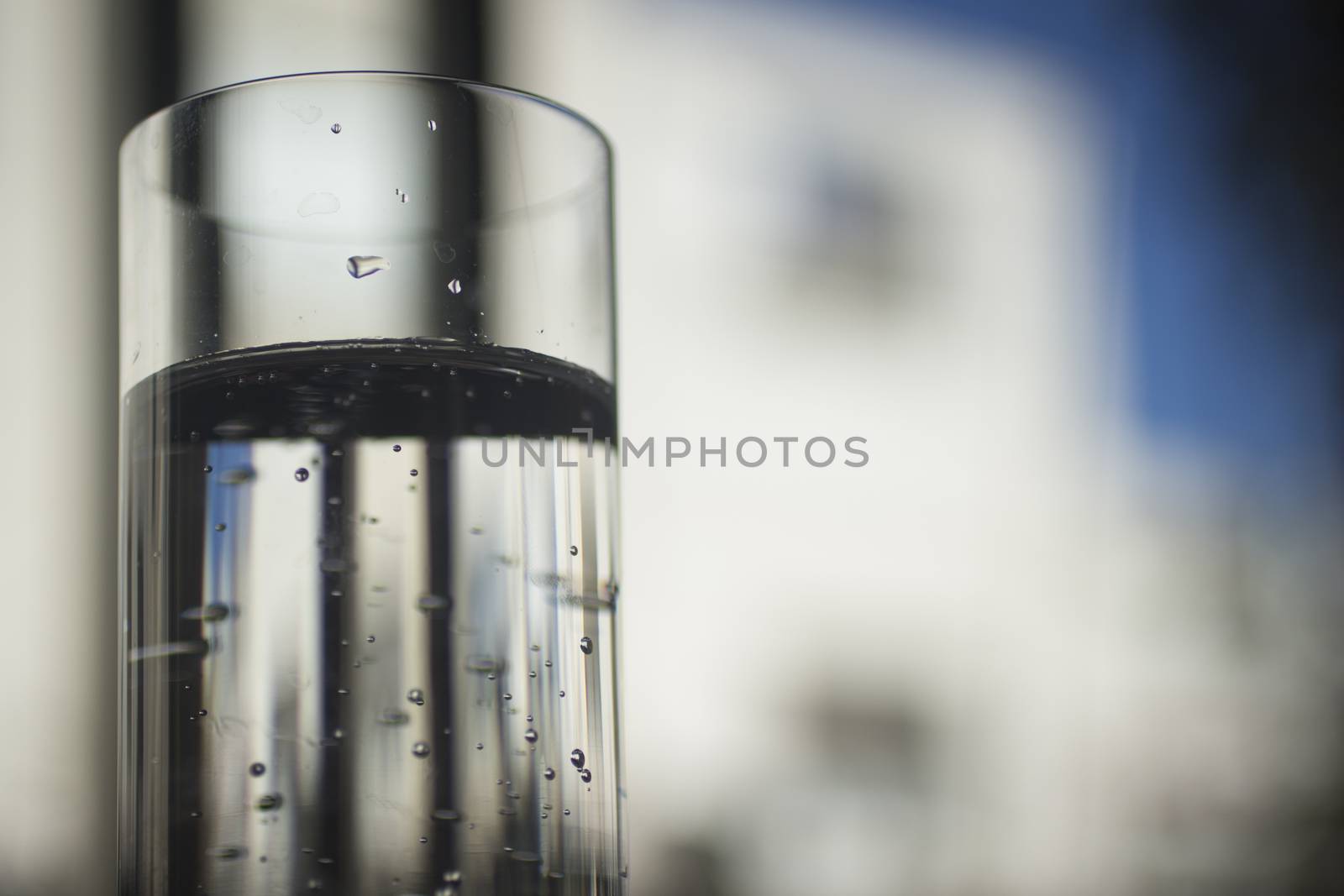 Glass of sparkling water soft drink closeup on carbon dioxide gas bubbles.