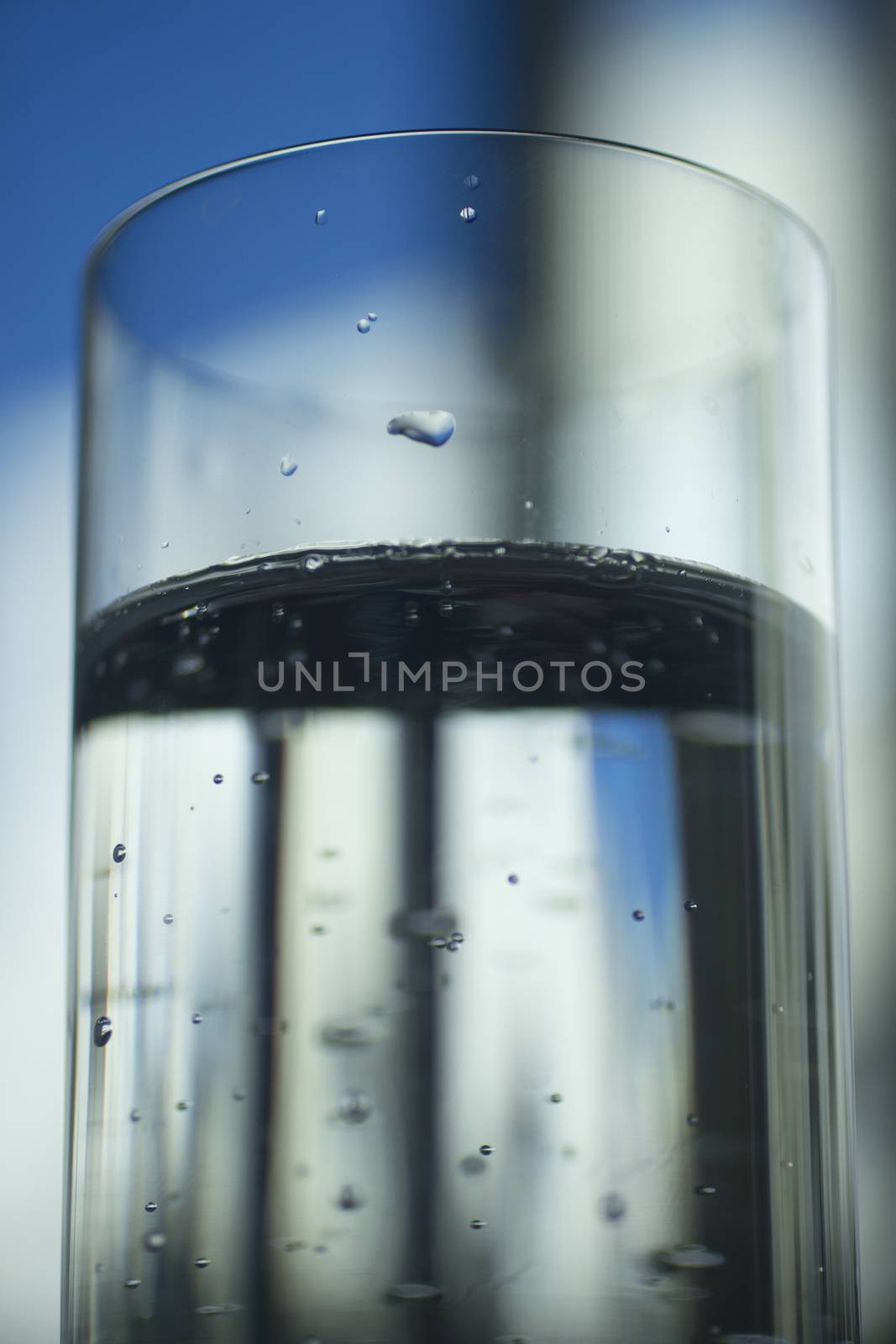 Glass of sparkling water soft drink closeup on carbon dioxide gas bubbles.