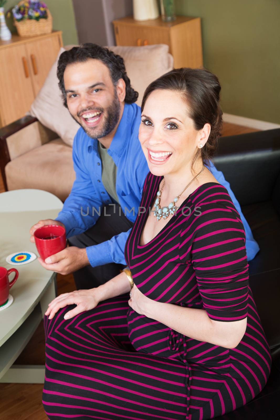 Laughing husband with smiling wife holding cups