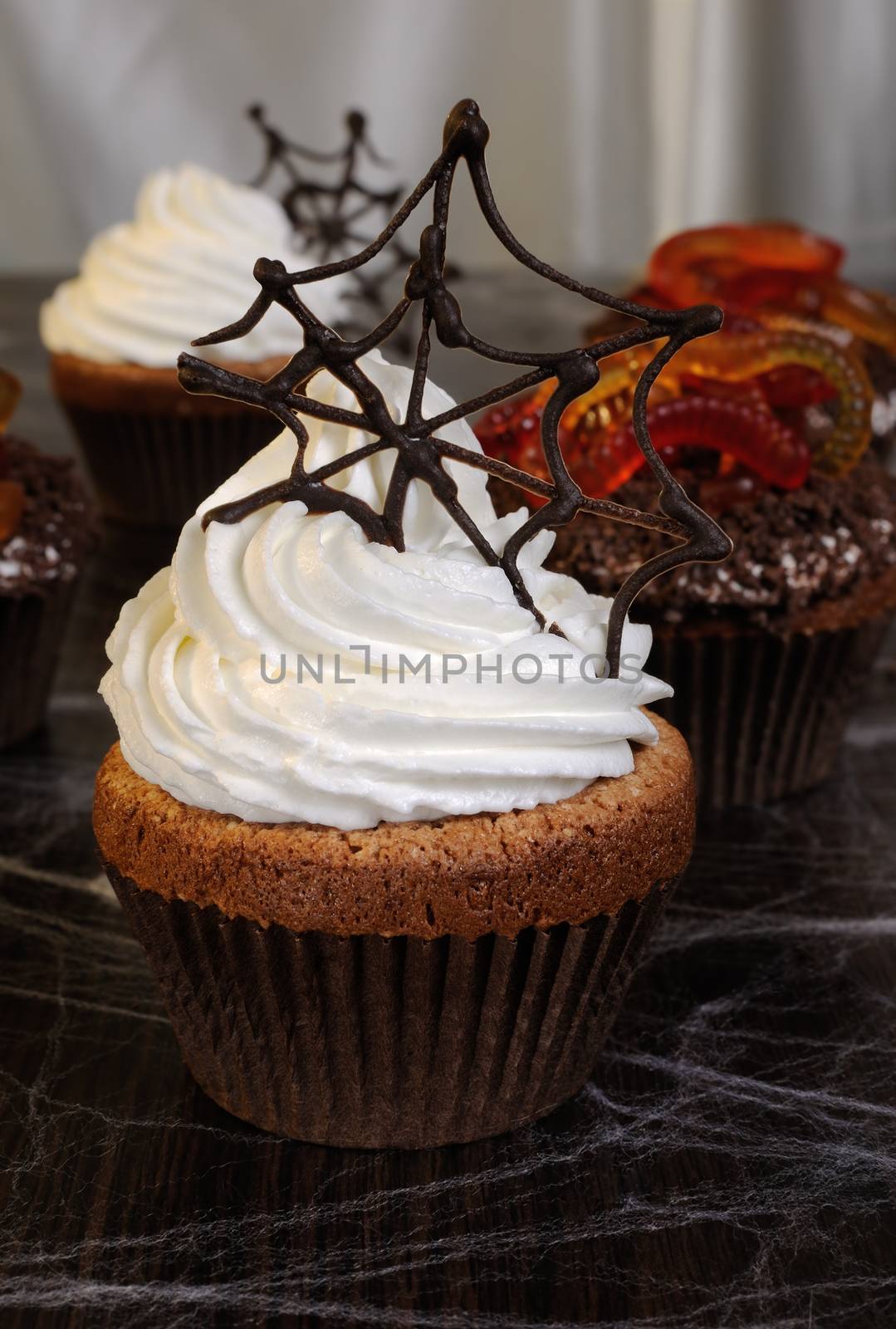 Muffin with whipped cream and chocolate cobwebs