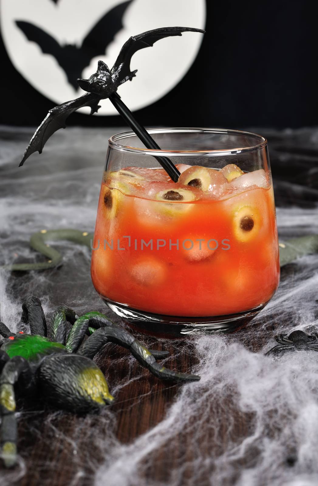 A glass of tomato juice with olives on ice